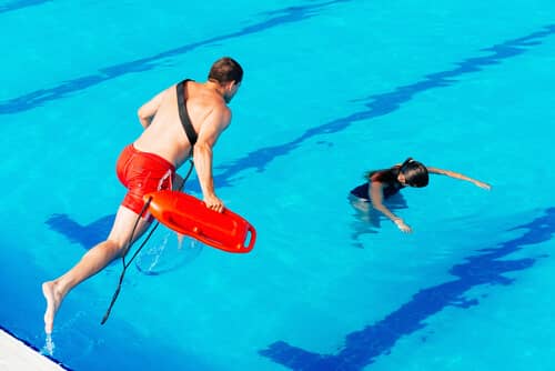 Lifeguard jumping to save drowning person