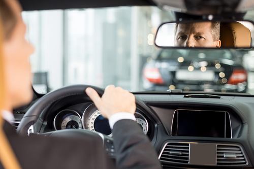 Man looking at rear-view mirror