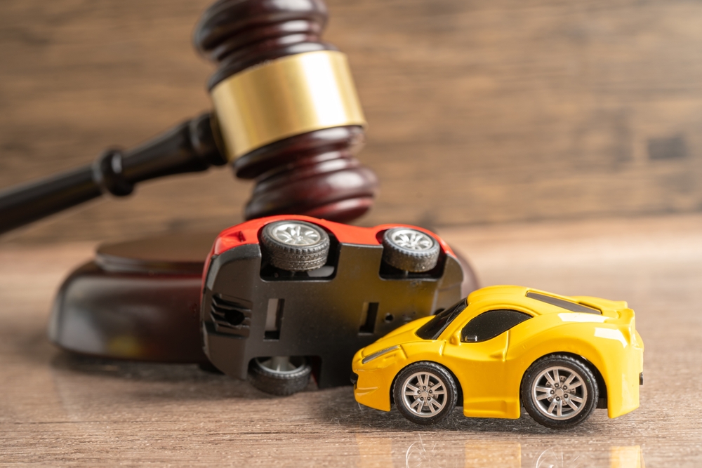 gavel and two toy cars simulating car accident