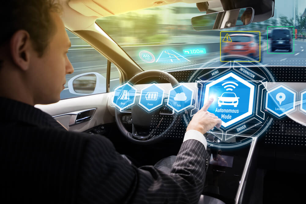 Driver activating autonomous mode in self-driving car, highlighting liability risks and accident responsibility in automated vehicles