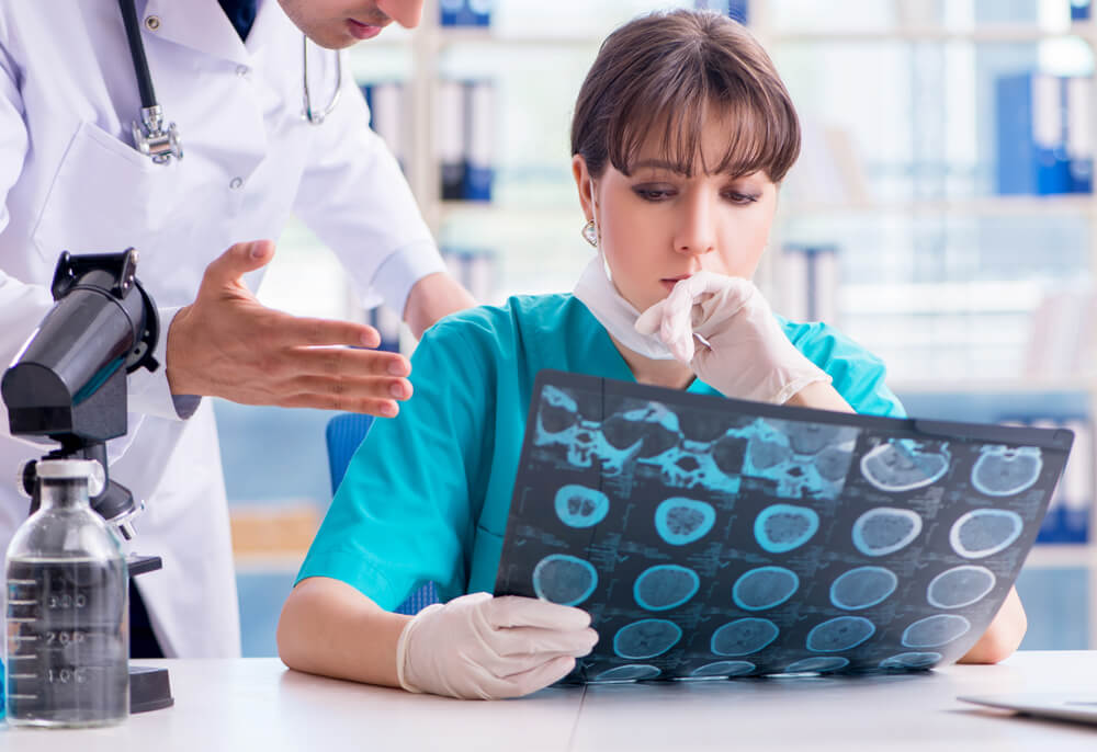 Concerned radiologists reviewing brain scan for possible misdiagnosis in medical imaging case